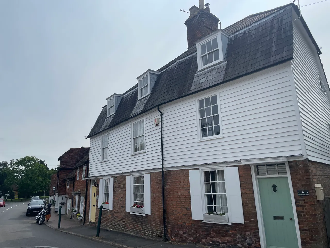 A white weatherboarded period house on a corner of the main street in Lamberhurst village.