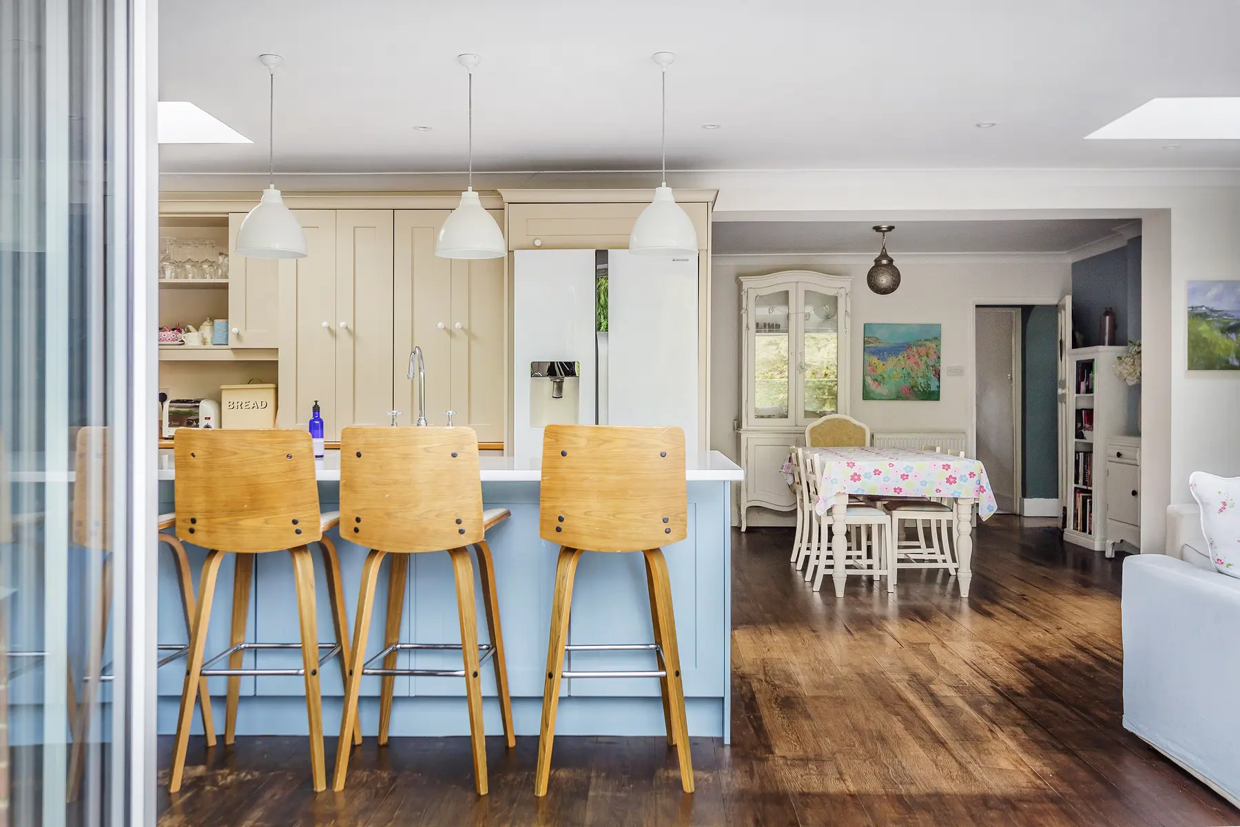 A bright open-plan kitchen and dining room with pendant lights and bifold doors, dressed for family life — a Kings Estates home