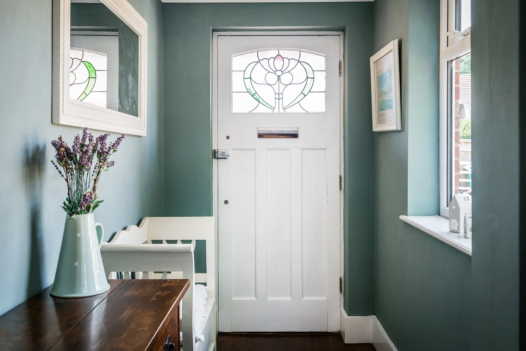 A period entrance hall with a stained-glass front door and panelled walls in a Kings Estates managed home