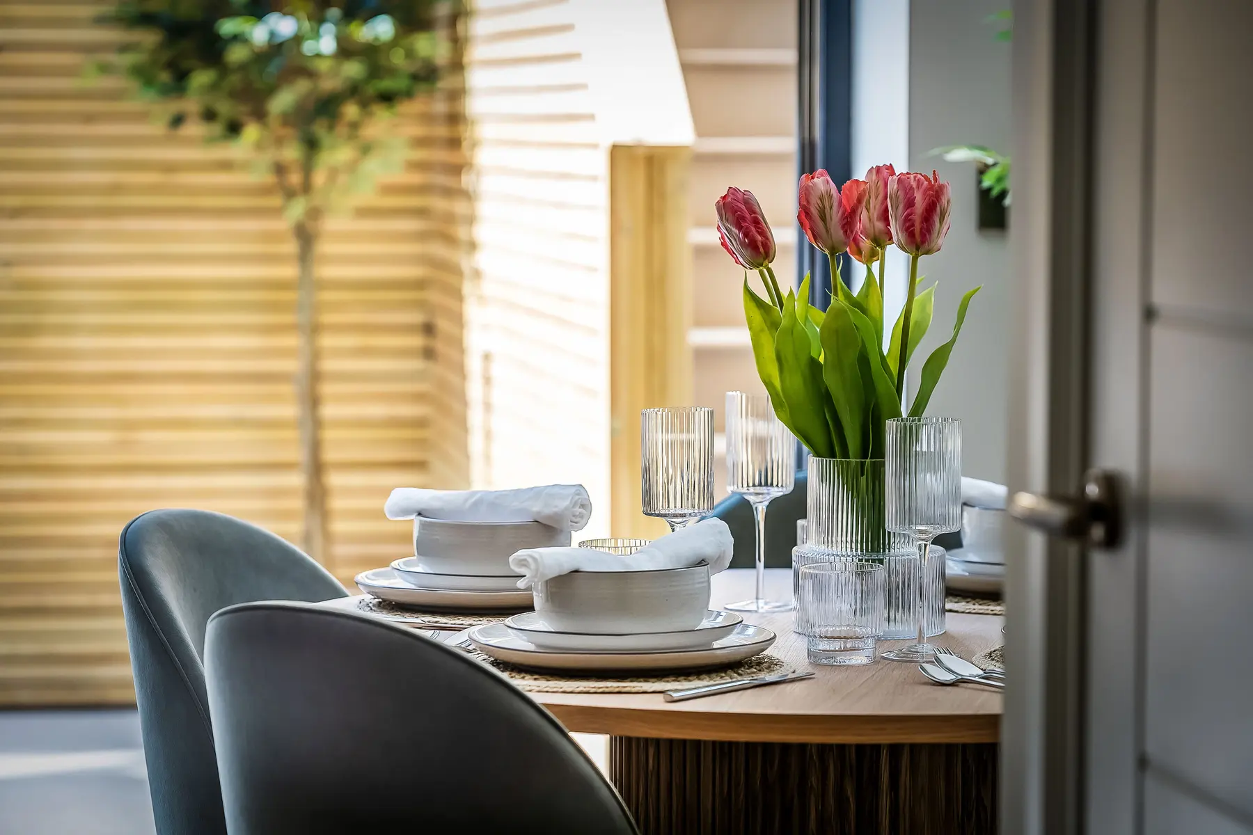 A dressed dining table at North Farm Road — tulips, linen and glassware in morning light